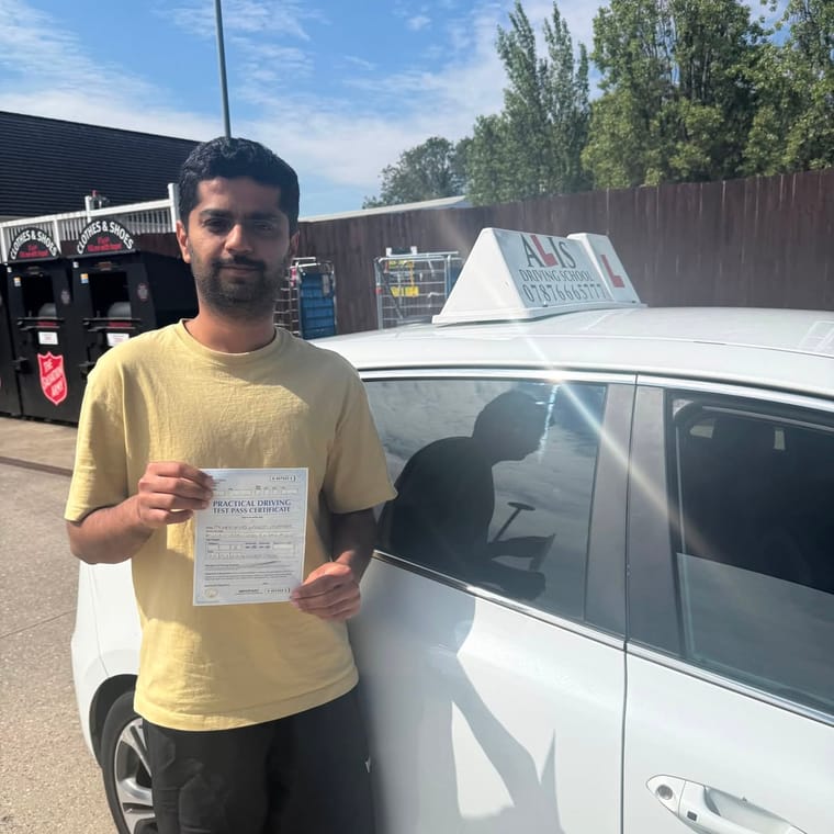A pupil holding their practical driving test pass certificate beside Ali's car in King's Lynn.
